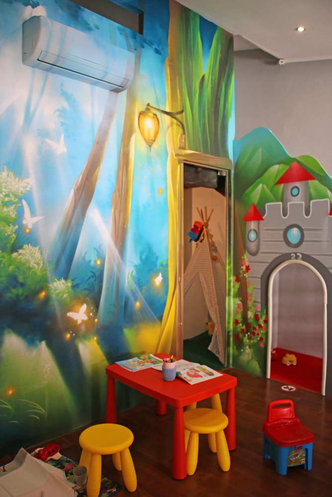A beautiful mural with a kids table and toys in O Ninho cafe in the Old Town of Lagos
